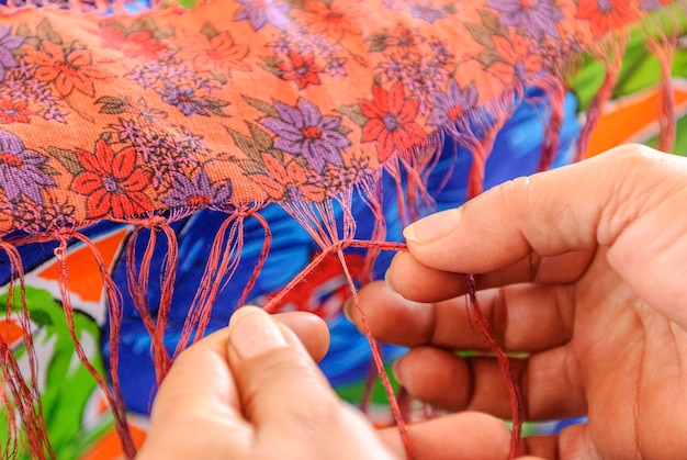 Hands embroidering floral pattern